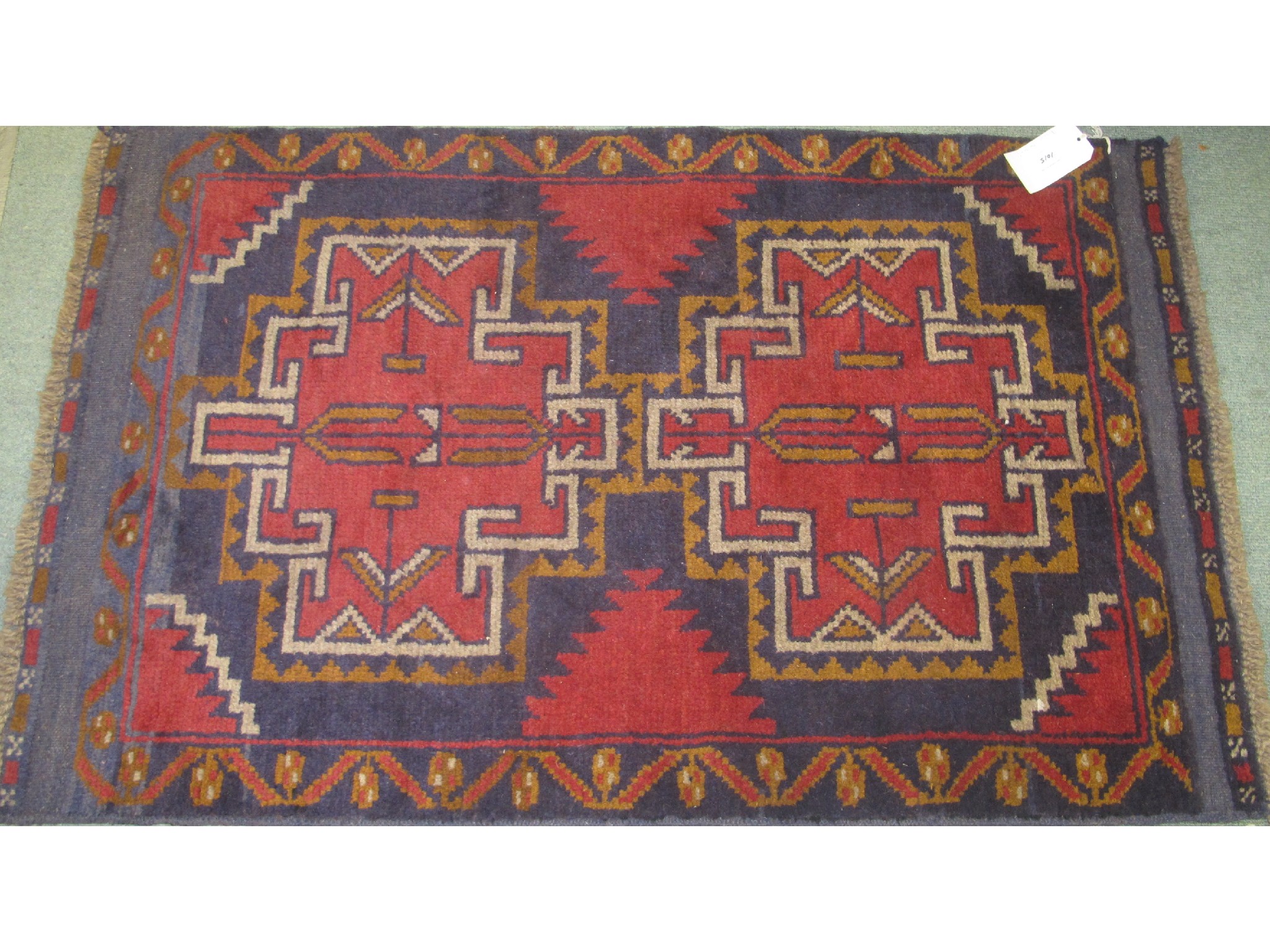 Appraisal: A Persian Balochi rug on a red and blue ground