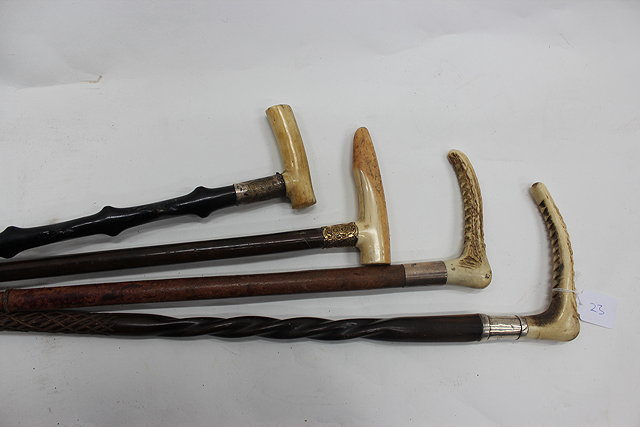 Appraisal: TWO EARLY TH CENTURY WALKING STICKS with ivory crutch handles