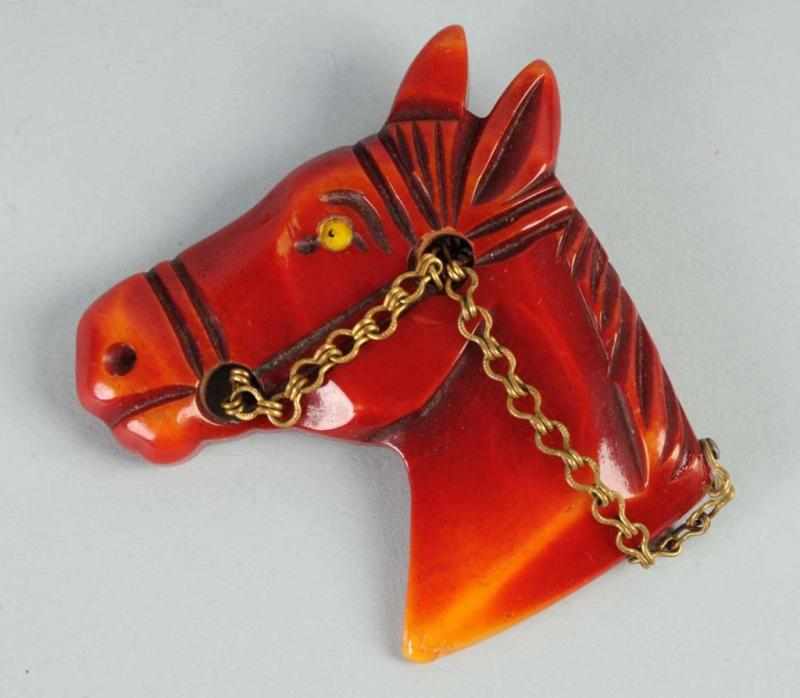 Appraisal: Bakelite Carved Red Horse Pin Description Brass harness No damage