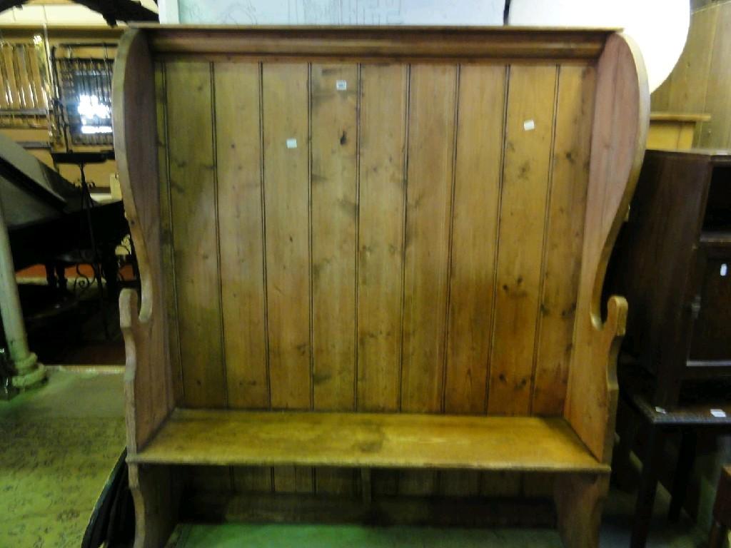 Appraisal: An antique stripped pine settle with raised panelled back and