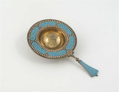 Appraisal: A Norwegian silvergilt enamelled tea strainer decorated in light blue