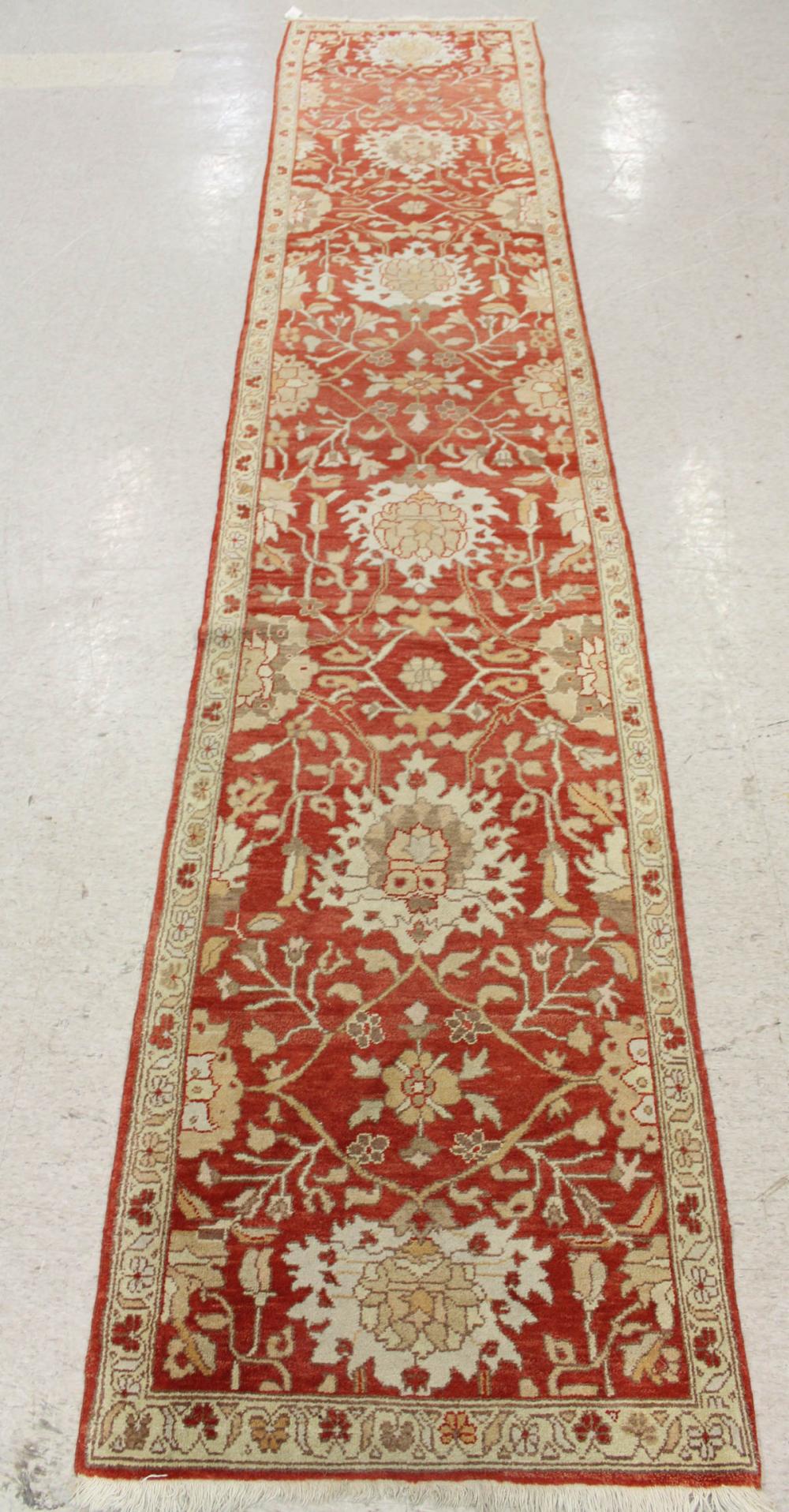 Appraisal: HAND KNOTTED ORIENTAL RUNNER Indo-Persian overall floral design on persimmon