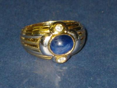 Appraisal: A GENTLEMAN'S SAPPHIRE RING the oval cabochon sapphire set between