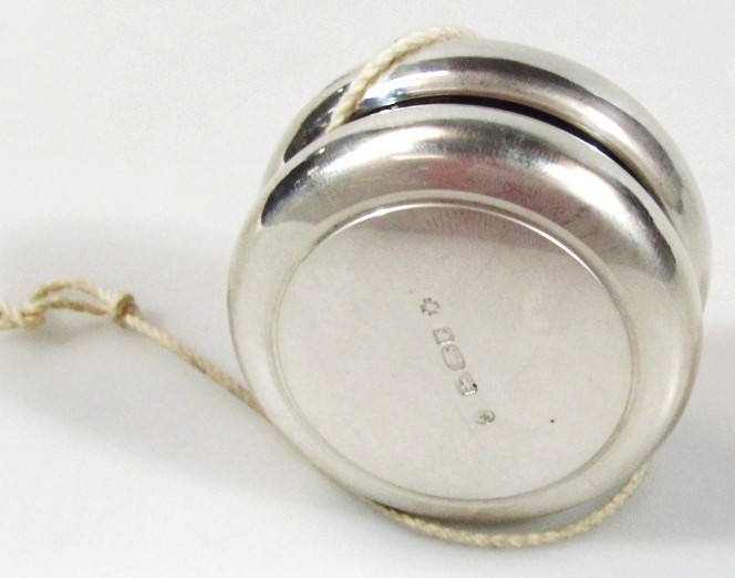 Appraisal: A silver yo-yo of circular outline strung to the centre