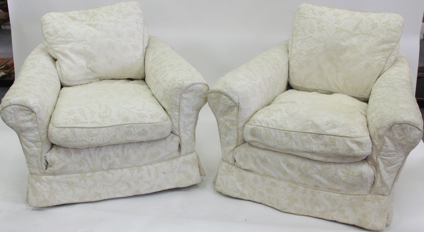 Appraisal: A pair of upholstered armchairs with deep seats and loose