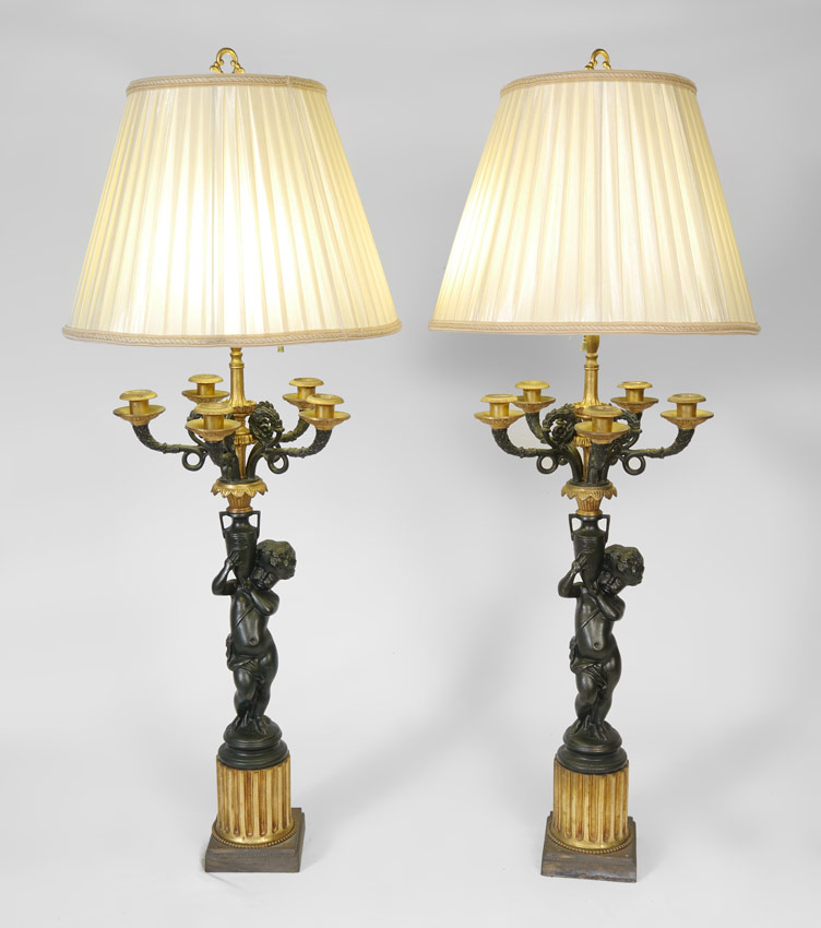 Appraisal: PAIR FIGURAL PUTTI CANDELABRA LAMPS Figural cast metal bases featuring