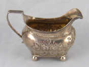 Appraisal: A Georgian silver cream jug on ball feet with reeded