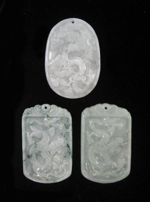 Appraisal: THREE CHINESE CARVED JADE PENDANTS each light green jade pendant