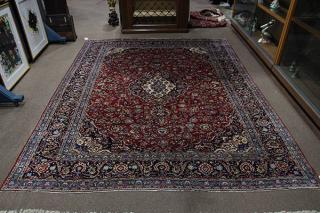 Appraisal: Persian-Kashan carpet having a navy medallion within red medallion with