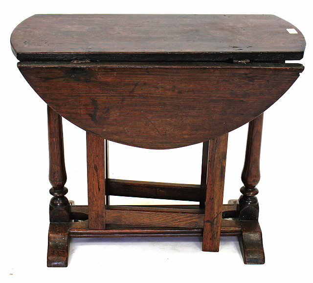 Appraisal: AN OVAL OAK GATELEG TABLE with turned end supports and