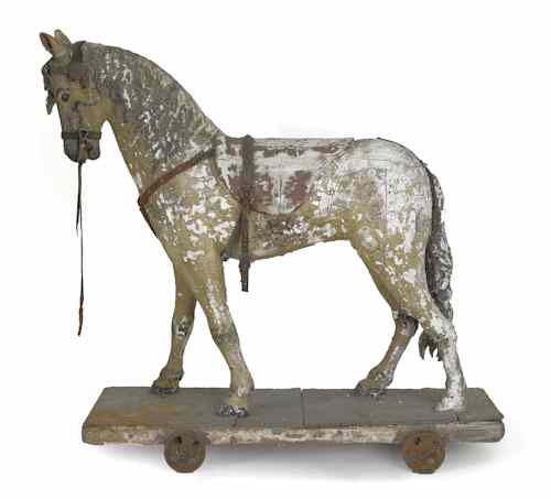 Appraisal: Carved and painted riding horse th c on a wheeled