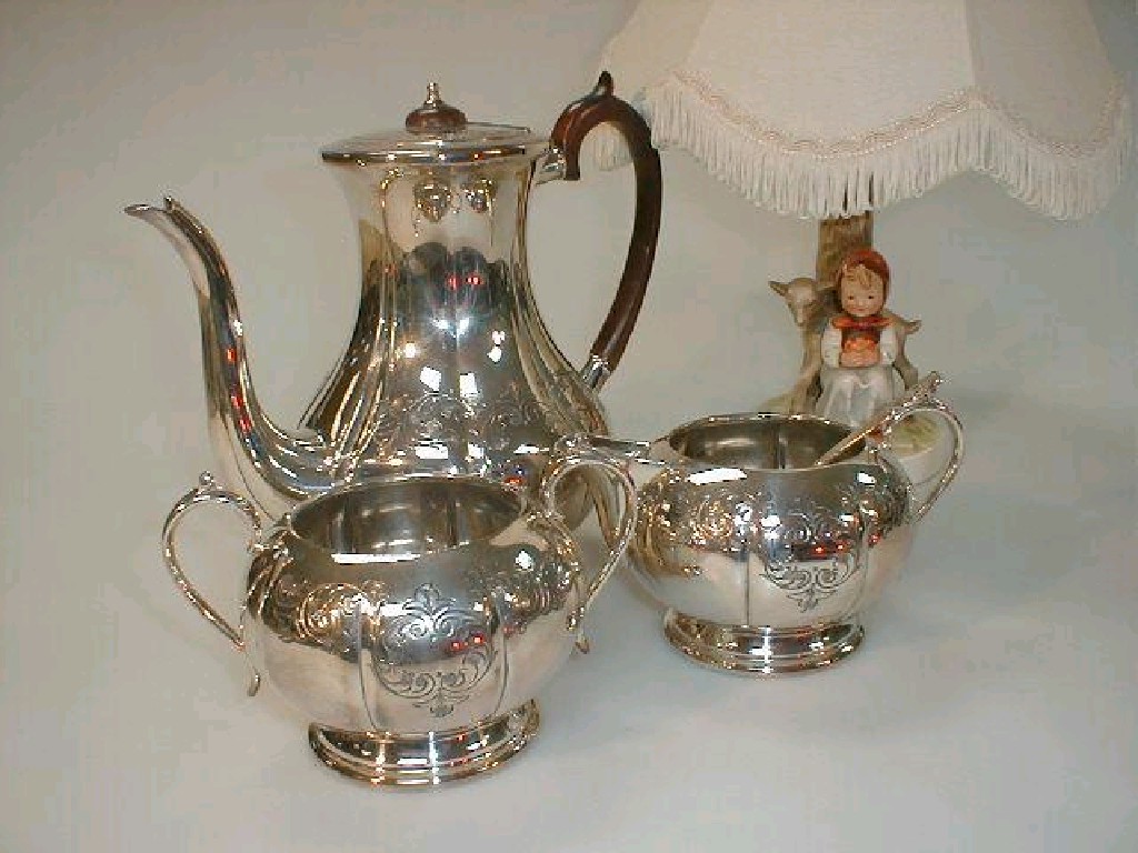 Appraisal: An electroplate three piece tea set and a Hummel table