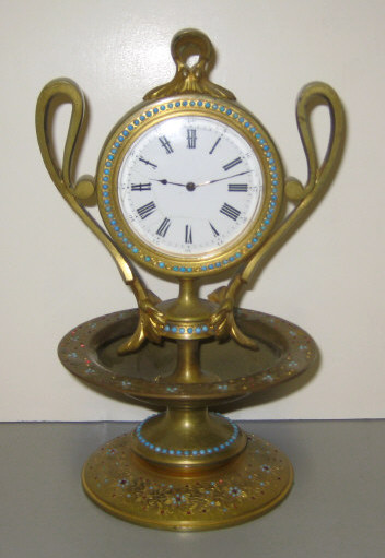 Appraisal: CONTINENTAL GILT METAL MINI CLOCK Two-handled flask form with white