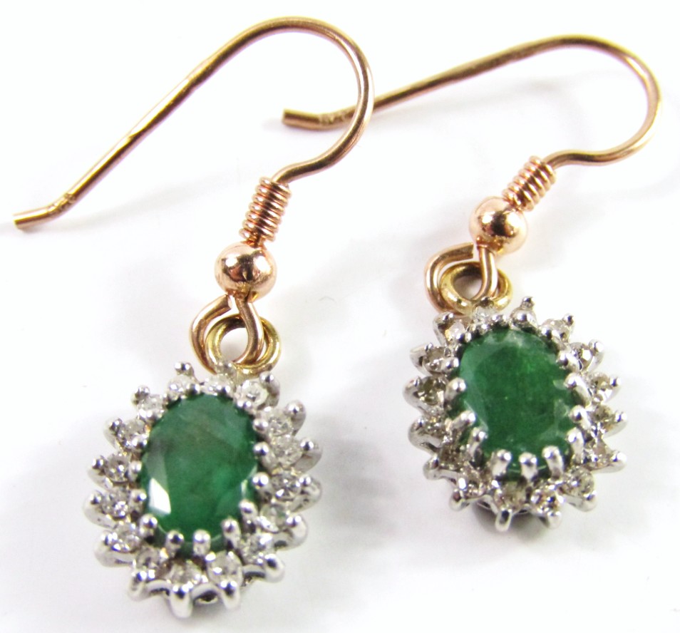 Appraisal: A pair of emerald and diamond oval cluster earrings set