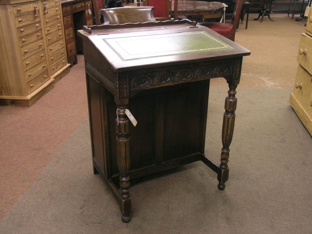 Appraisal: A reproduction dark oak Davenport sloping hinged top with inset