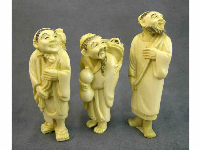 Appraisal: Three tall standing ivory netsuke depicting a Chinese man with