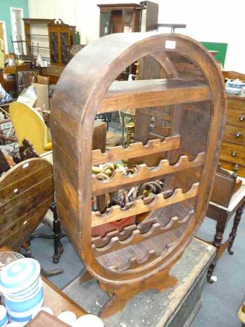 Appraisal: A TH CENTURY HARDWOOD WINE RACK of oval form holding