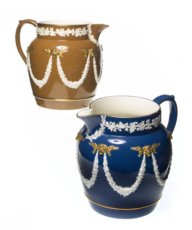 Appraisal: TWO WEDGWOOD MATCHING GILT QUEENSWARE JUGS with ram's heads and