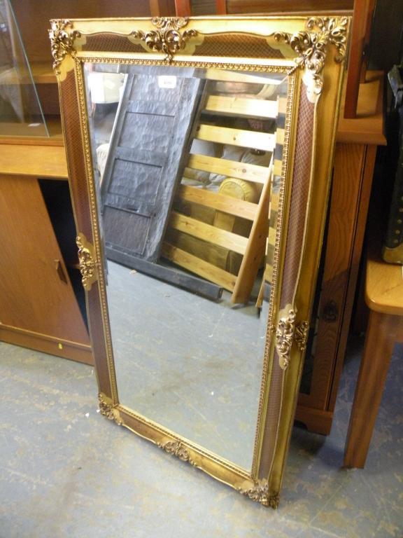 Appraisal: A gilt rectangular wall mirror with a bevelled plate