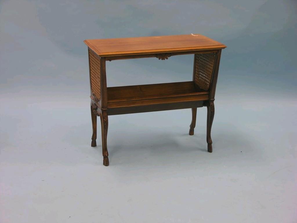 Appraisal: An Edwardian walnut book trough with double-caned ends on moulded