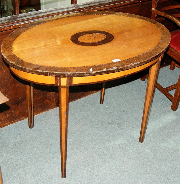 Appraisal: A Sheraton style satinwood and rosewood oval occasional tablewith central