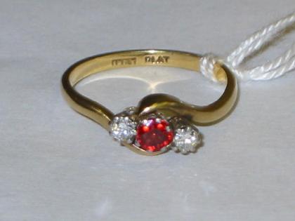 Appraisal: A THREE STONE DIAMOND AND RUBY CROSSOVER RING the central