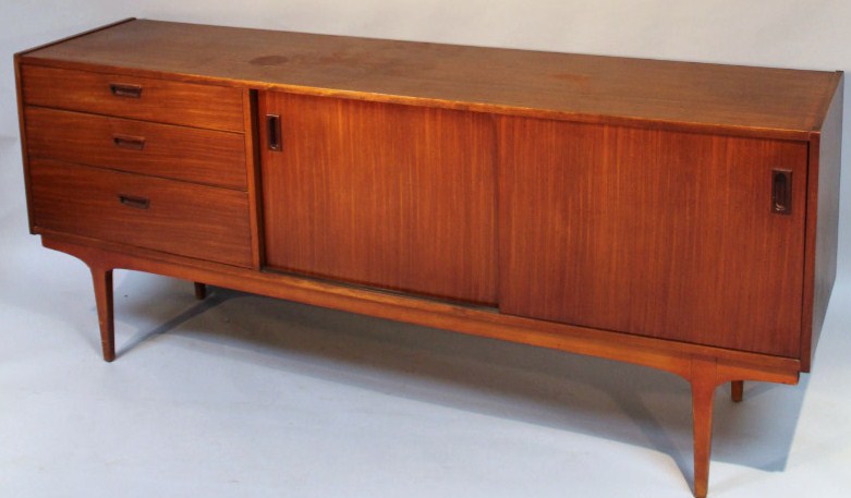 Appraisal: A 's teak sideboard centred by three drawers and sliding