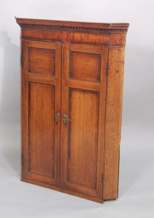 Appraisal: An early thC oak and mahogany banded corner cabinet with