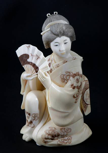 Appraisal: A small Japanese tinted ivory figure of a kneeling beauty