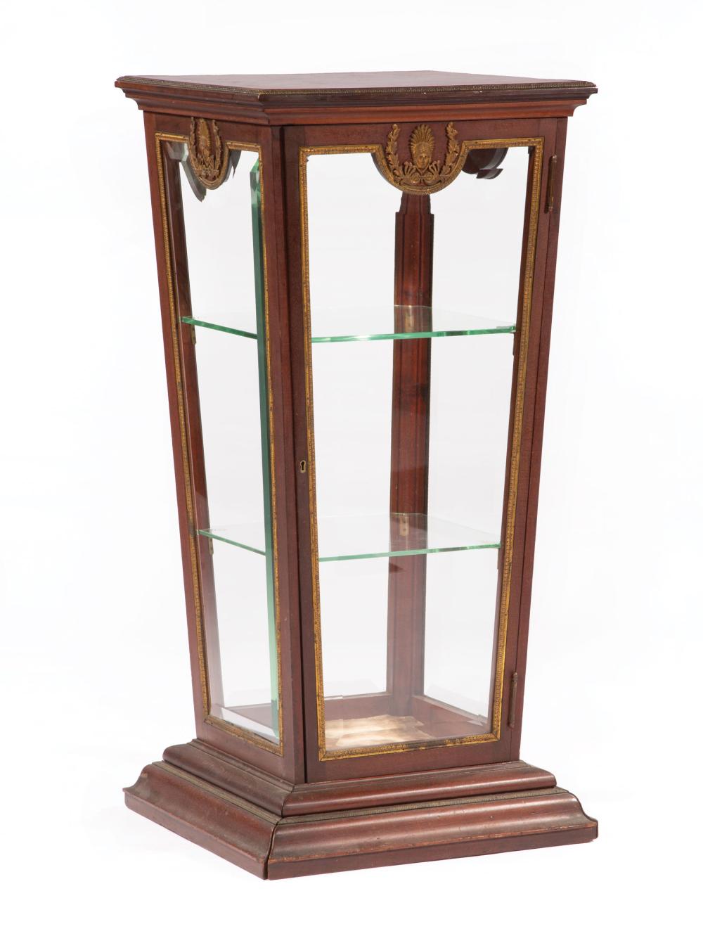 Appraisal: Neoclassical-Style Bronze-Mounted Mahogany Pedestal Vitrine th c reverse-tapered standard with