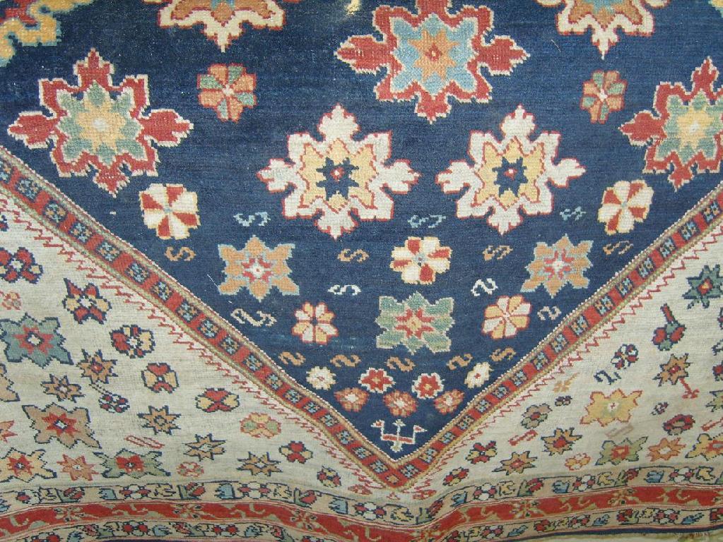 Appraisal: An eastern wool rug with blue ground lozenge shaped central