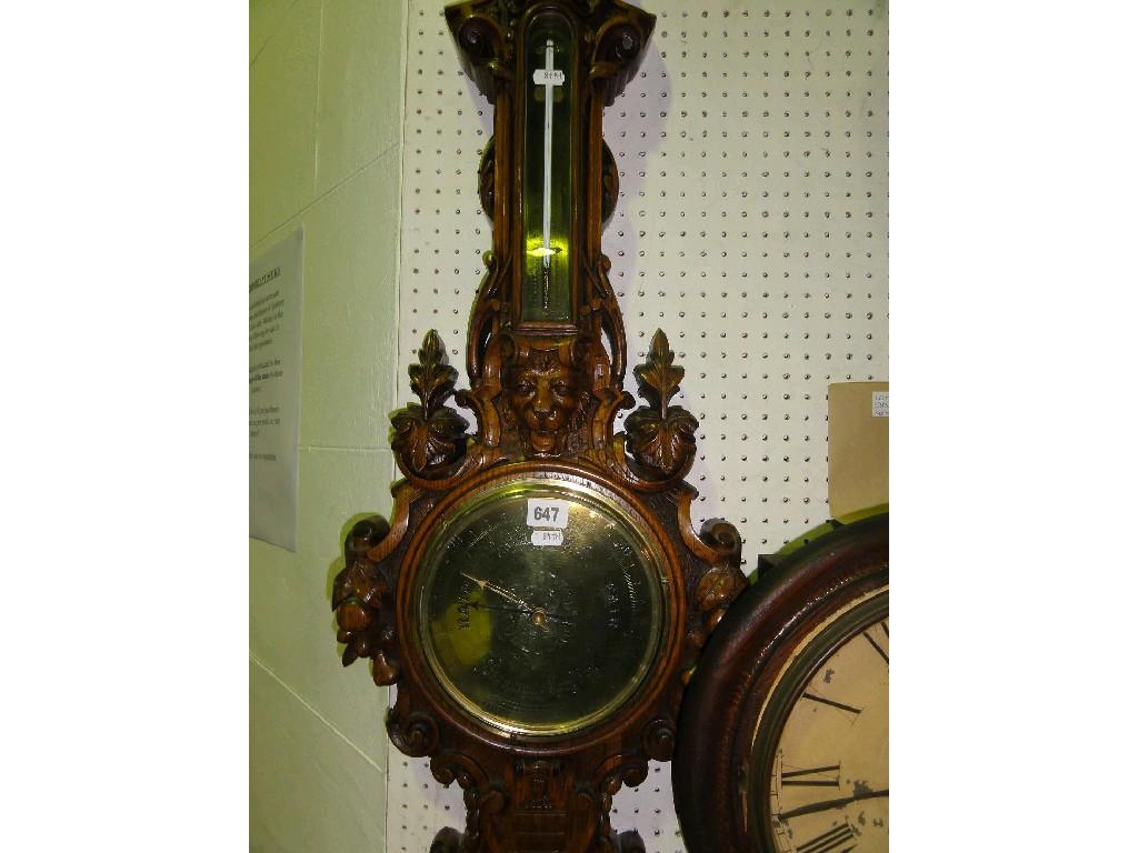 Appraisal: A barometer in an ornately carved oak frame with a