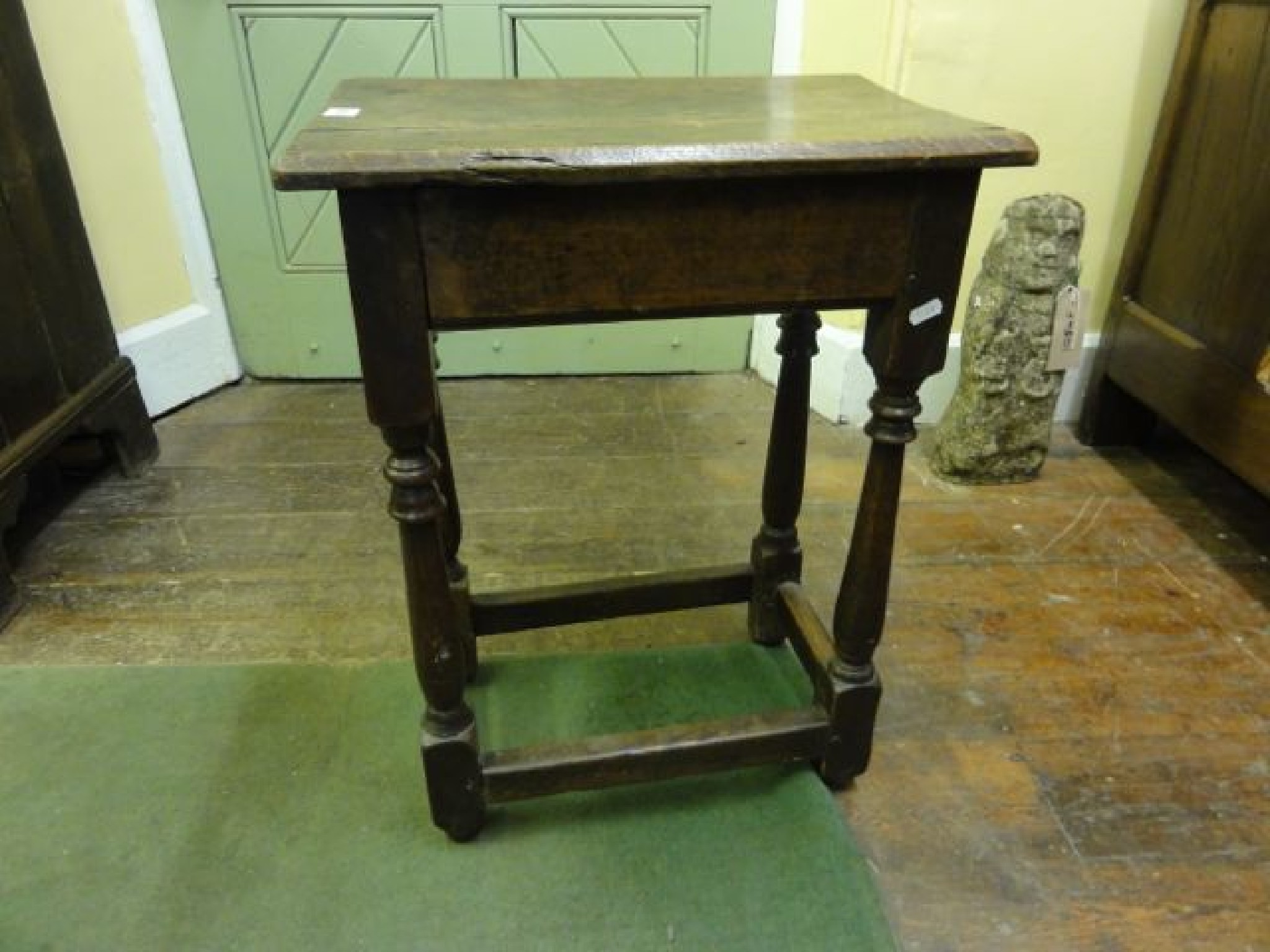 Appraisal: An old English oak stool raised on four gun barrel