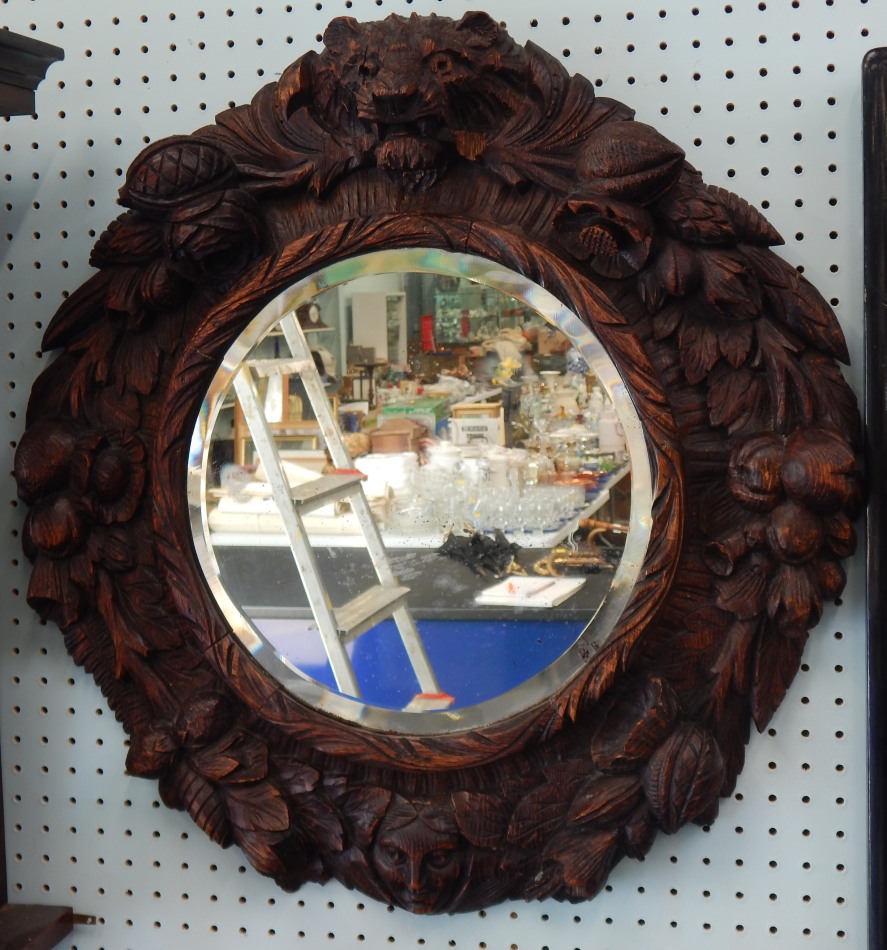 Appraisal: A Black Forest type carved wall mirror decorated overall with