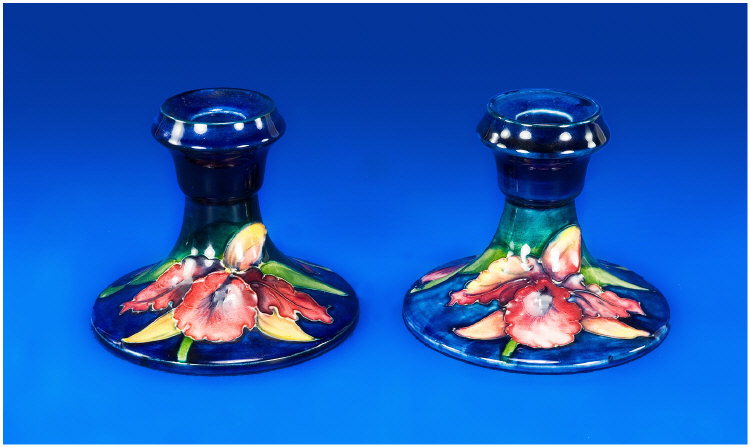 Appraisal: Moorcroft Pair Of Squat Shaped Candlesticks C s Orchid design