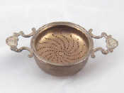 Appraisal: A silver two handled tea strainer and stand London wt