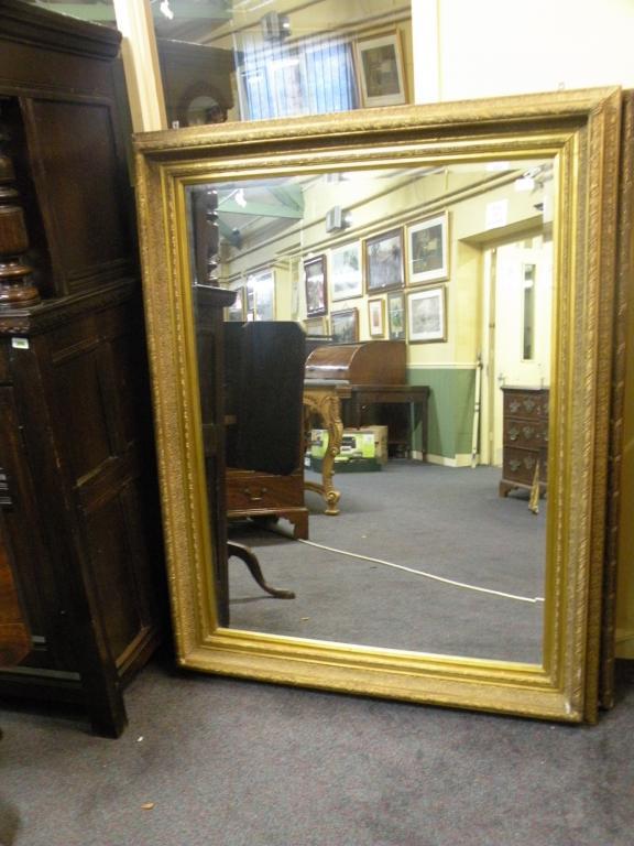 Appraisal: A large gilt rectangular wall mirror with a bevelled plate