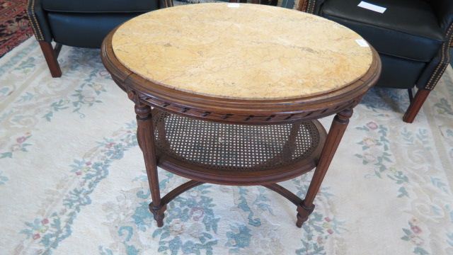 Appraisal: French Style Marble Top Table oval caned lower shelf