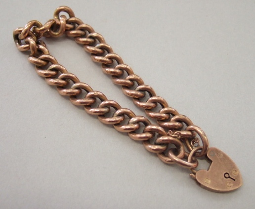 Appraisal: A gold curb link bracelet on a gold heart shaped