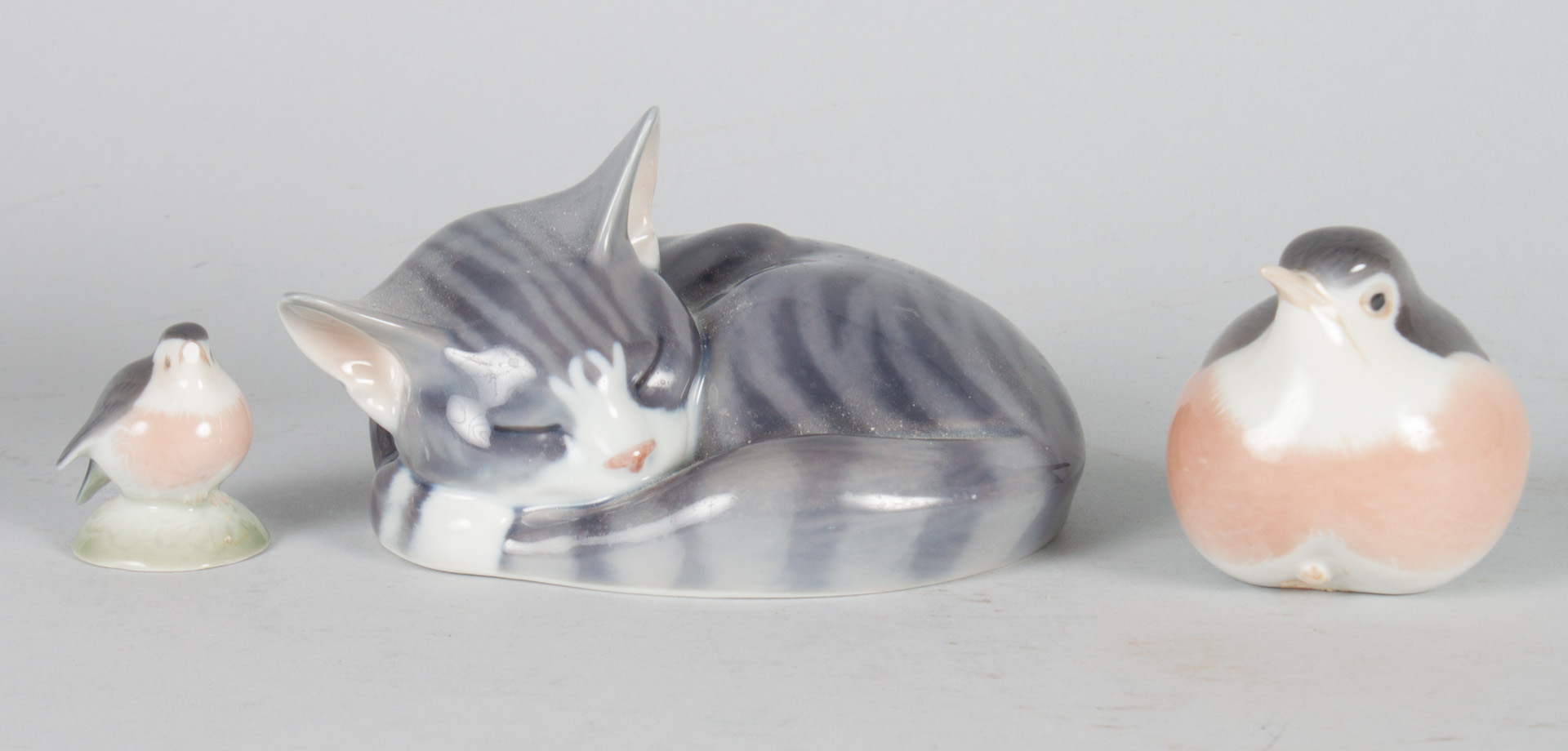 Appraisal: Three Royal Copenhagen porcelain animals sleeping cat and two songbirds