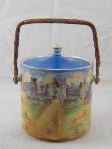 Appraisal: A ceramic biscuit barrel with lid and cane swing handle