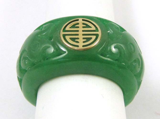 Appraisal: CHINESE CARVED GREEN JADE RING with a k yellow gold