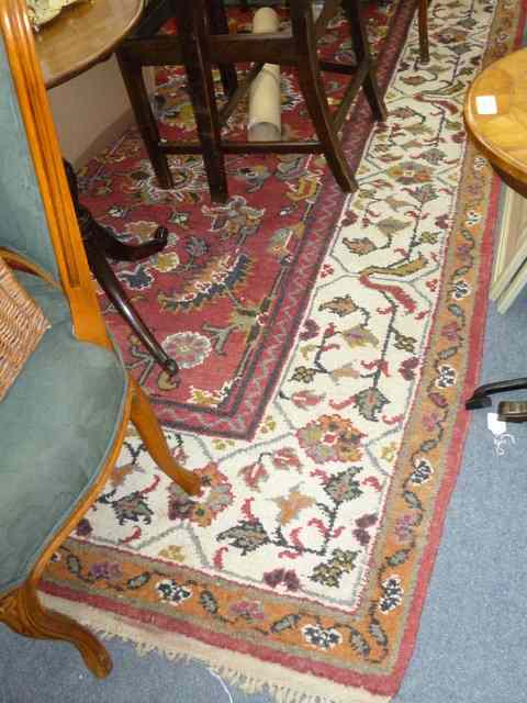 Appraisal: A RED GROUND RUG with banded border and geometric designs