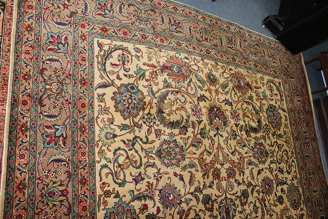 Appraisal: A PERSIAN TABRIZ GREEN AND CREAM GROUND RUG with scrolling