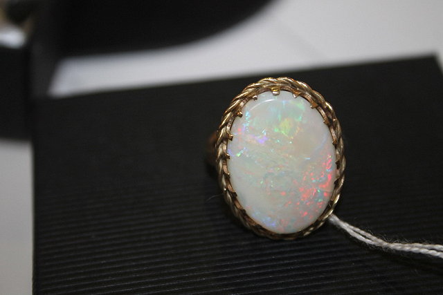 Appraisal: A DRESS RING with oval opal setting and rope-twist border