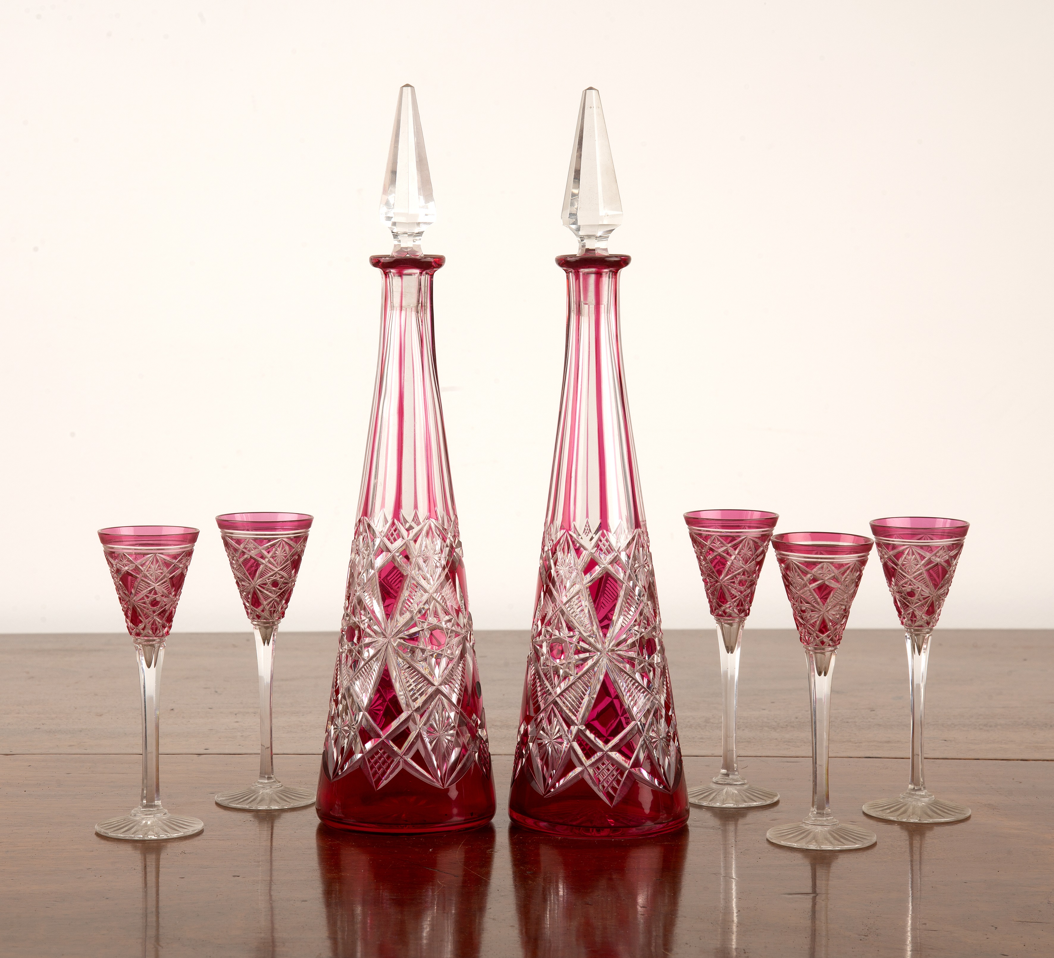 Appraisal: Bohemian flashed glass drinking set comprising of two conical decanters