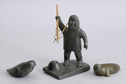 Appraisal: THREE ESKIMO CARVED SOAPSTONE FIGURES Comprising a fisherman raising a