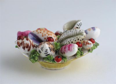 Appraisal: A miniature porcelain basket of seashells either side pierced with