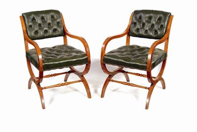 Appraisal: A pair of oak 'X' frame open armchairs upholstered buttoned