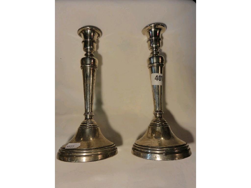 Appraisal: A pair of silver candlesticks with tapering columns and pedestal